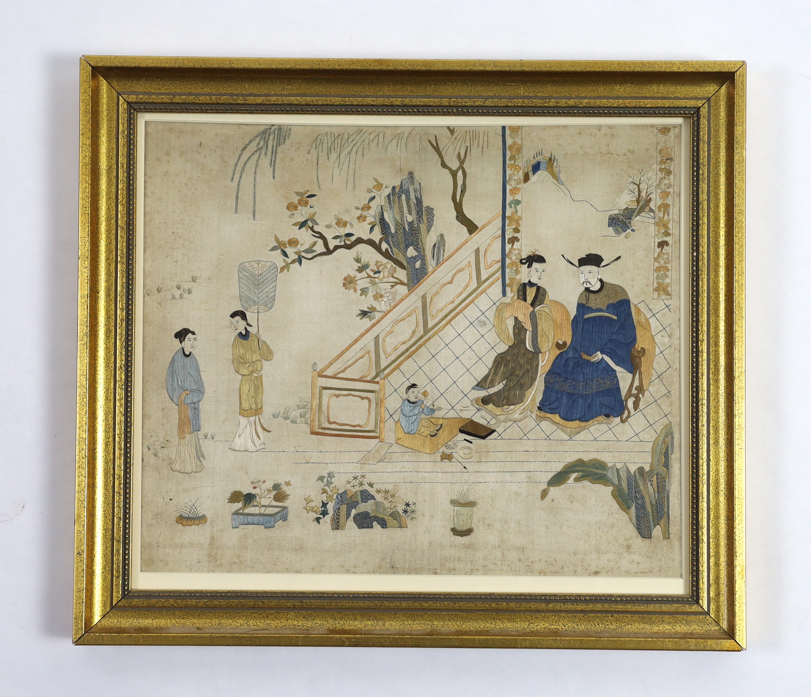 An early 19th century Chinese finely embroidered silk picture, of a nobleman, his wife and child and their attendants. Possibly a court scene. Worked mainly in stem stitch, in golds, blues, greens and white.